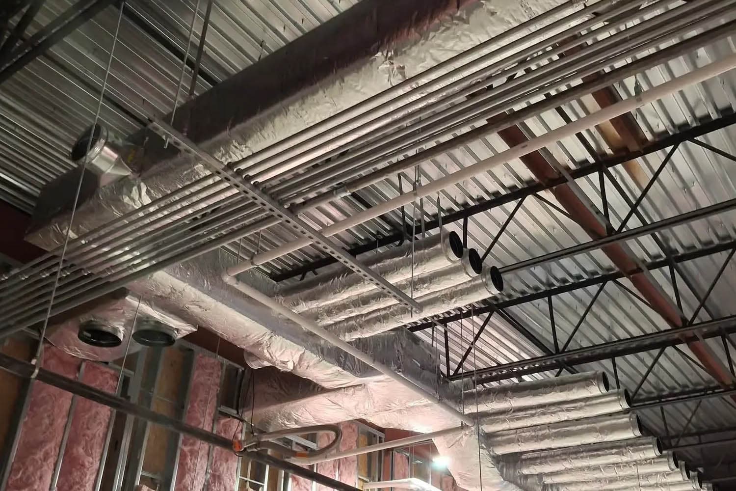 Insulated ductwork and piping in a commercial ceiling