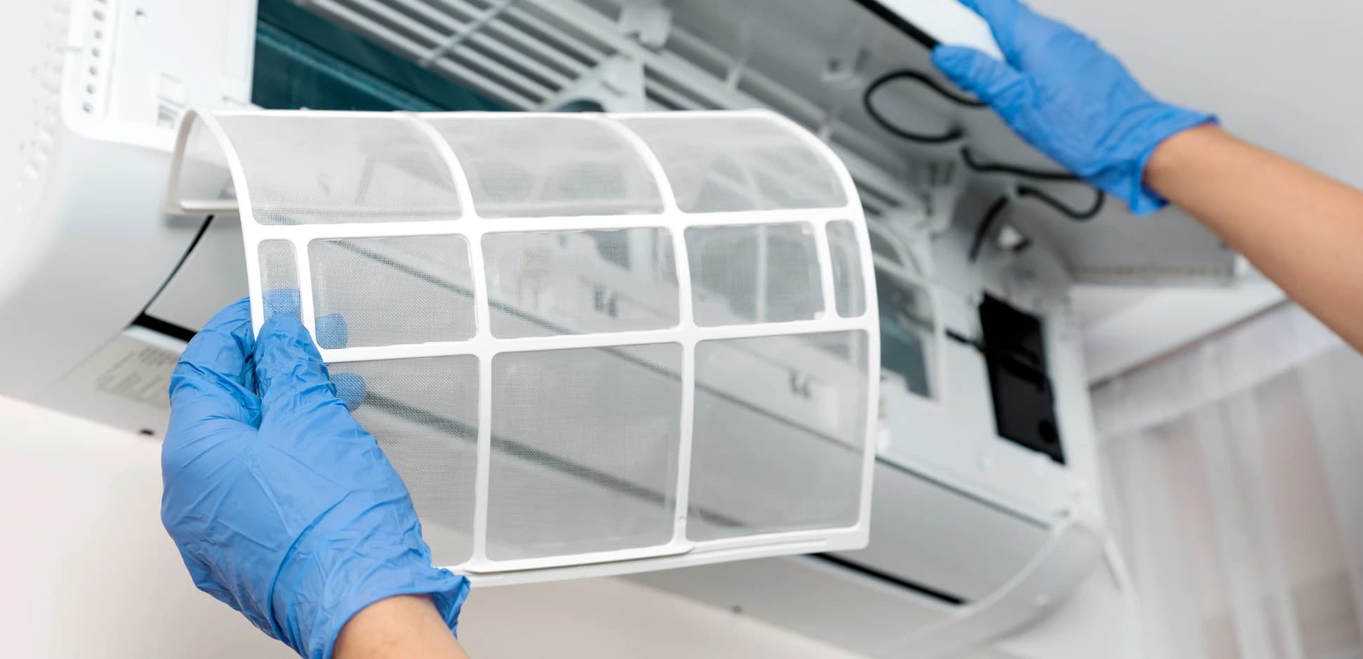 Technician cleaning the filter of a wall-mounted ductless mini-split