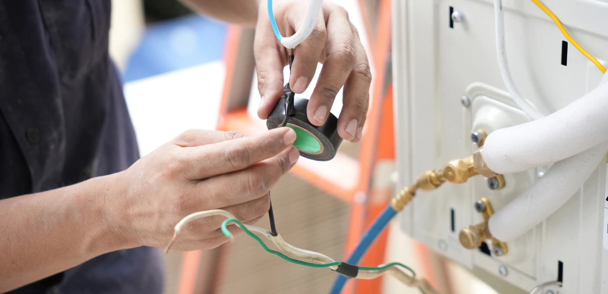 Technician installing a ductless mini-split indoor unit on a wall